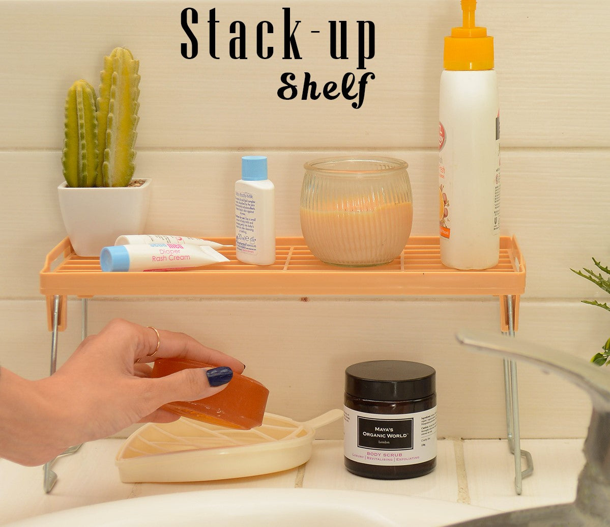 Stack-up shelf with various items on a bathroom counter, including soap and a candle.